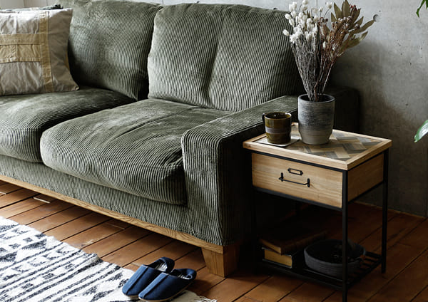 ヘリンボーン柄の天然木とスチールを組み合わせた収納付きサイドテーブルで、ソファーでのくつろぎの時間を快適に。
